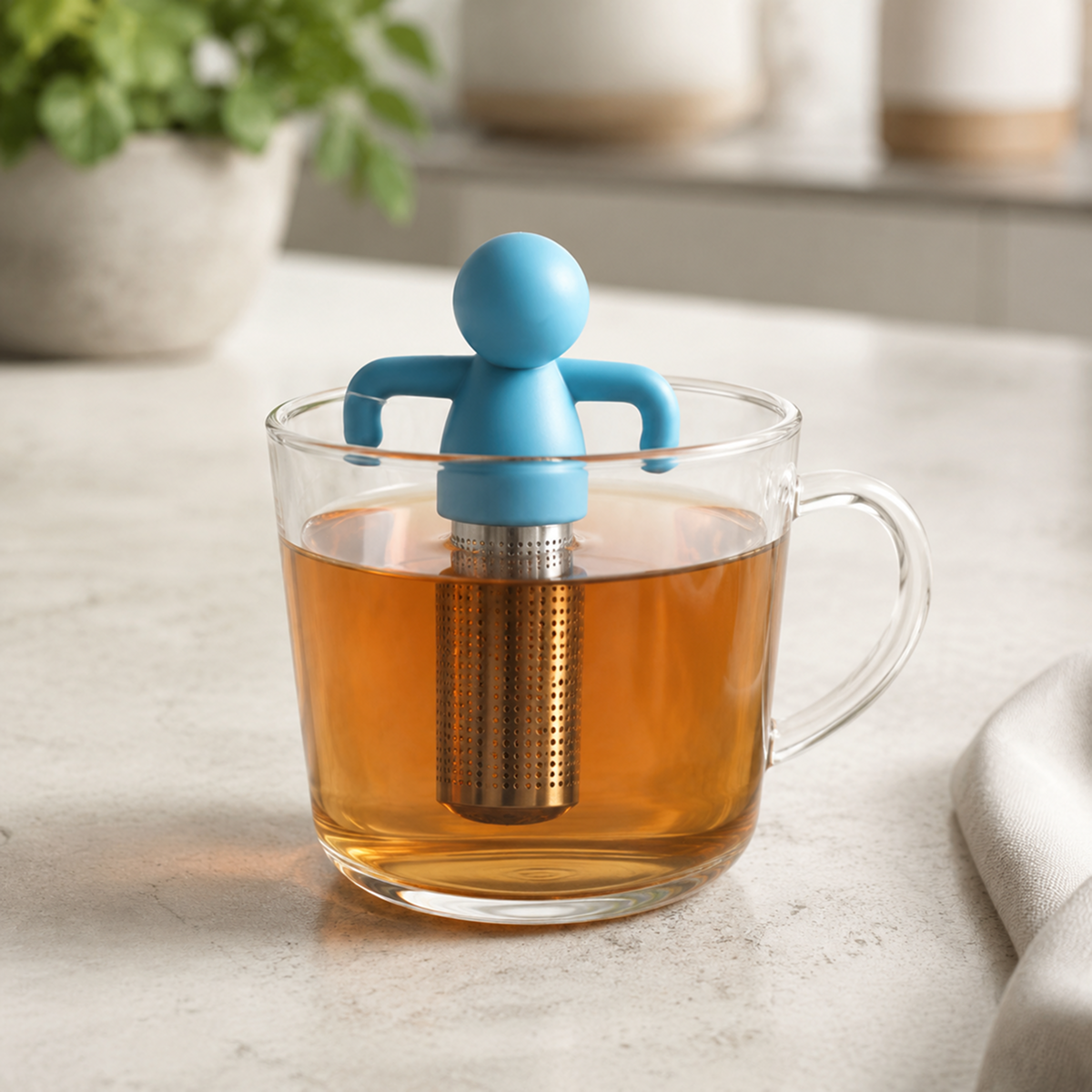 Reusable stainless steel loose-leaf tea infuser on a cup rim